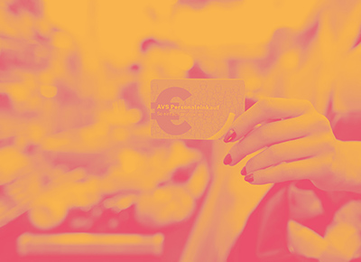 Foto: Eine Hand hält eine “AVS-Personaleinkauf”-Karte, im Hintergrund ein volles Kassenband. Darüber liegt ein Farbfilter in Pink und Gelb.