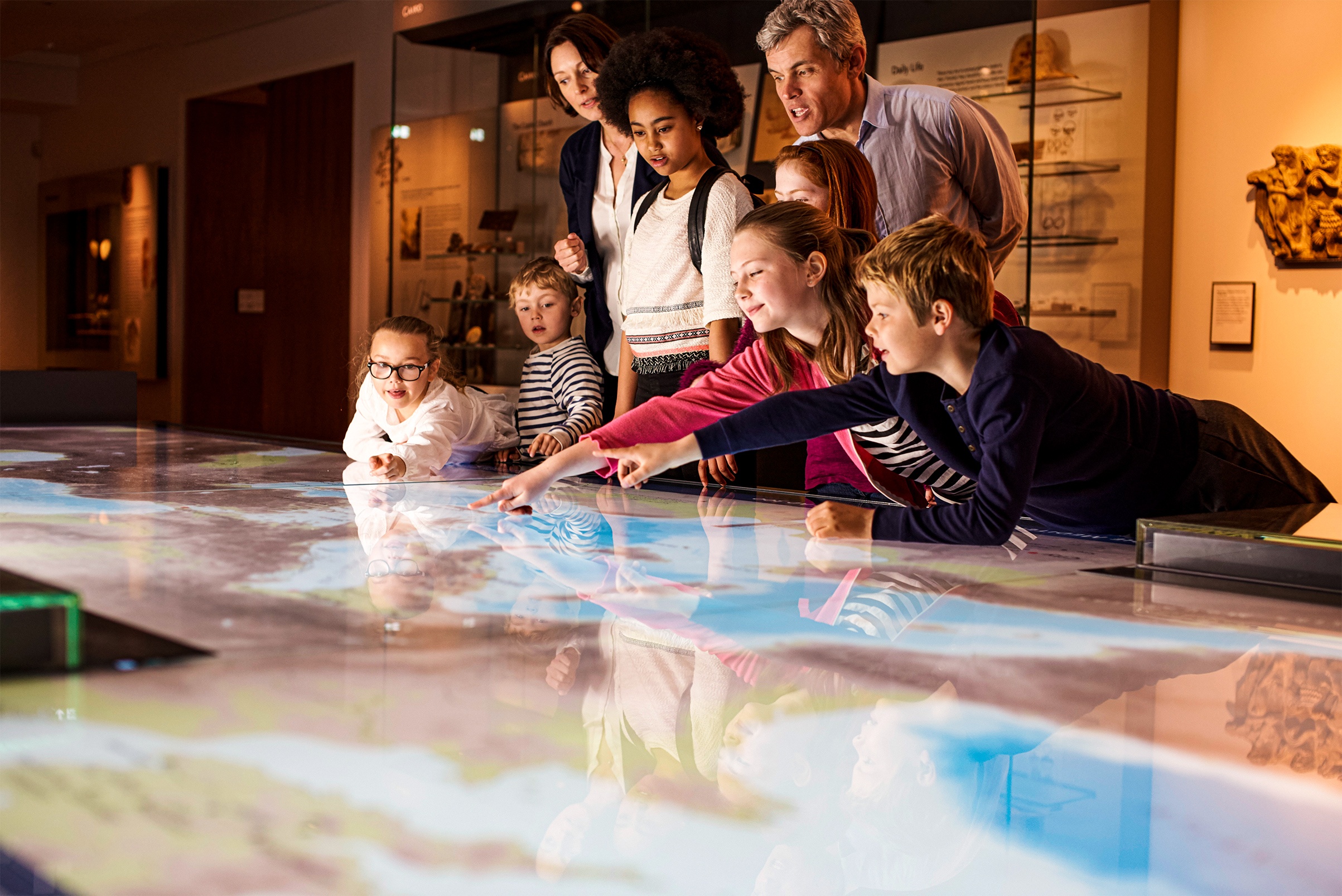Familie im Museum deutet auf eine Karte